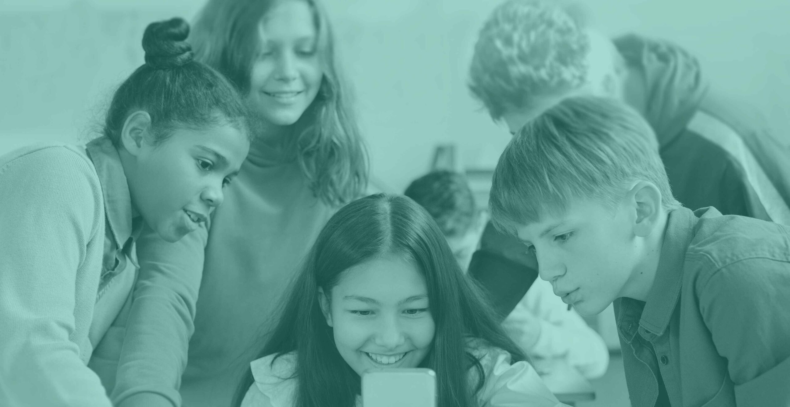 A group of children gather around to look at a phone screen.