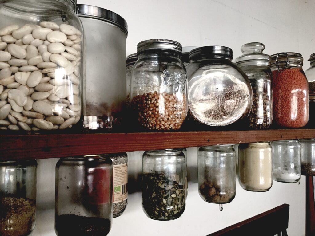 Jars on a kitchen shelf with diverse contents